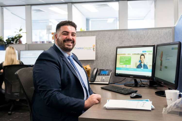 Owner of All Trades Cover Trade insurance expert sitting at a desk