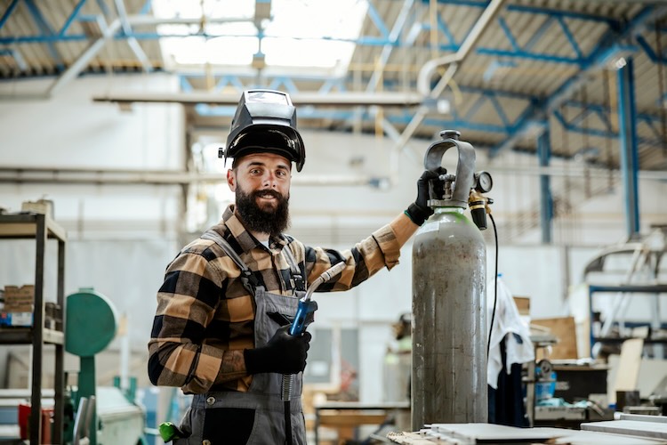 welders-insurance-warehouse Welder with welders insurance smiling in a warehouse