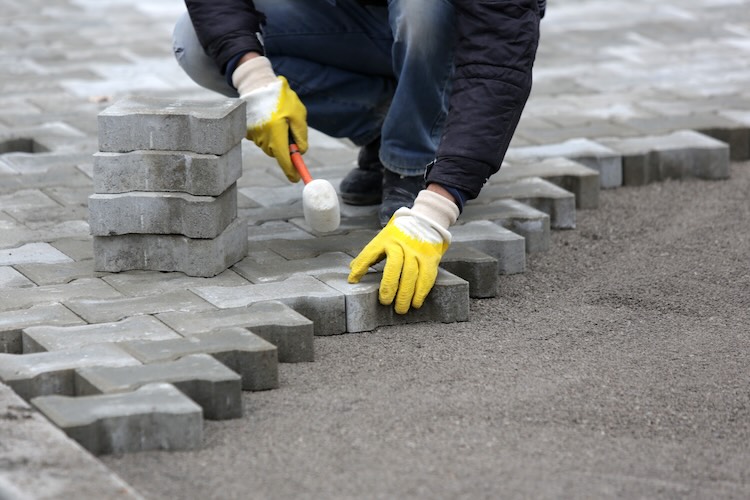 Paving stone worker Paving stone worker is putting down pavers during a construction of a city street