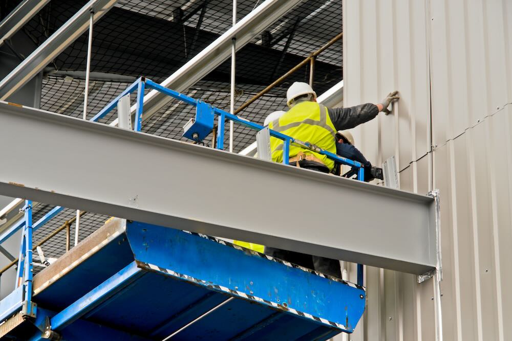 cladding-installer Insured cladding installer installing cladding to a building under construction,